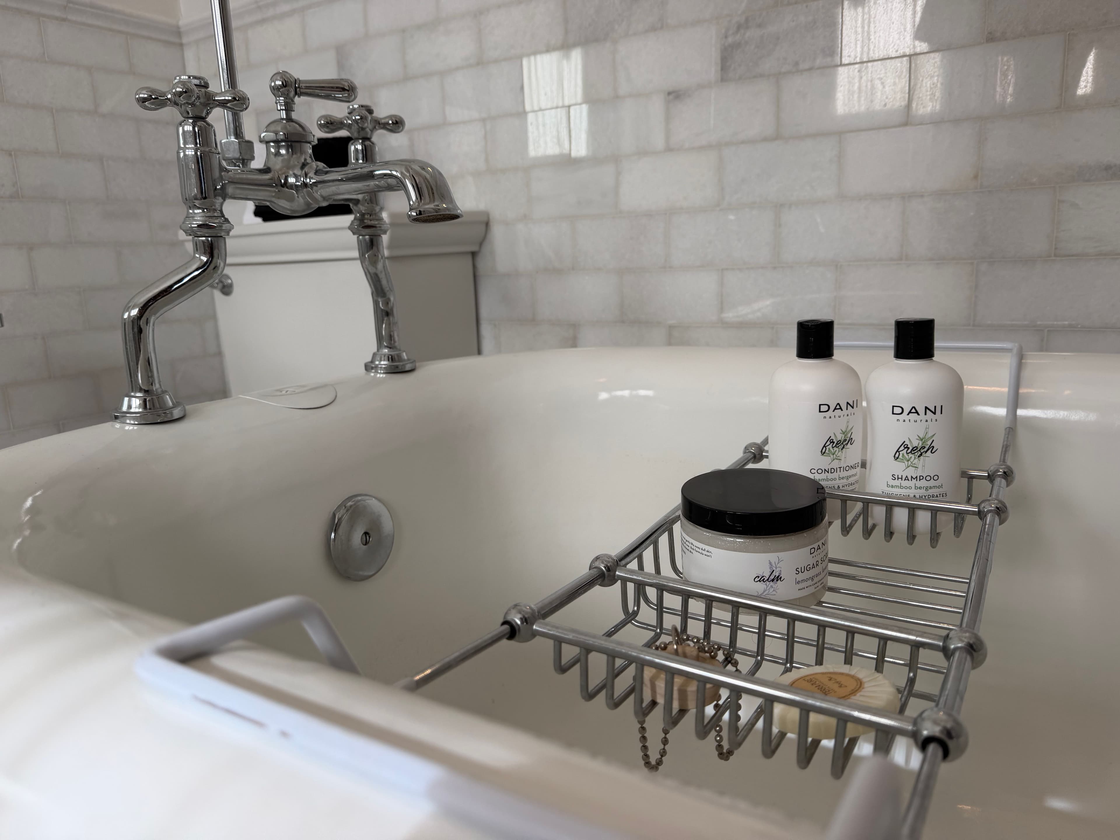 Claw-foot tub with bath amenities on a caddy